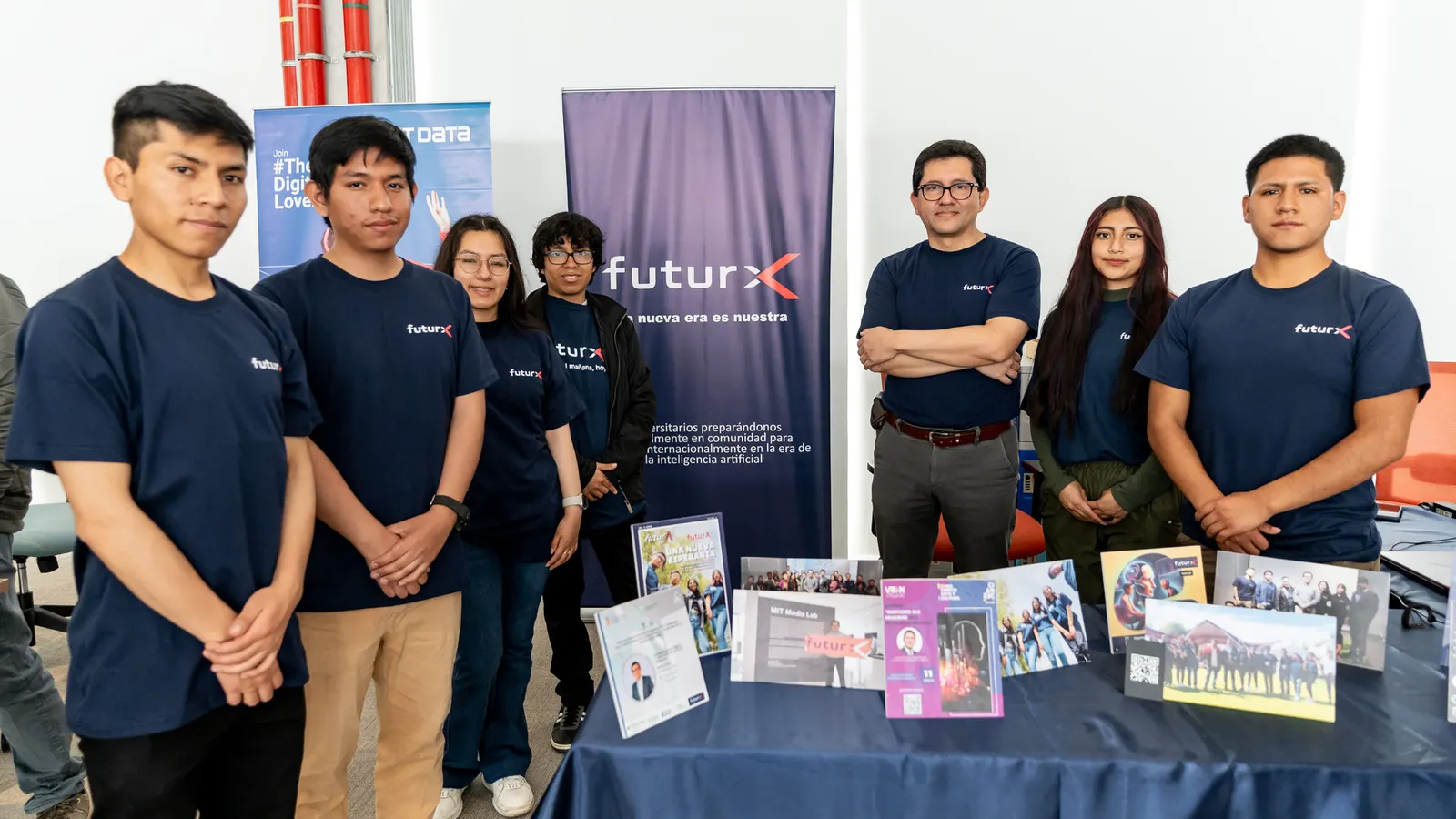 Seis integrantes de futurX junto a su banderola y a la mesa del stand en el VR Day.